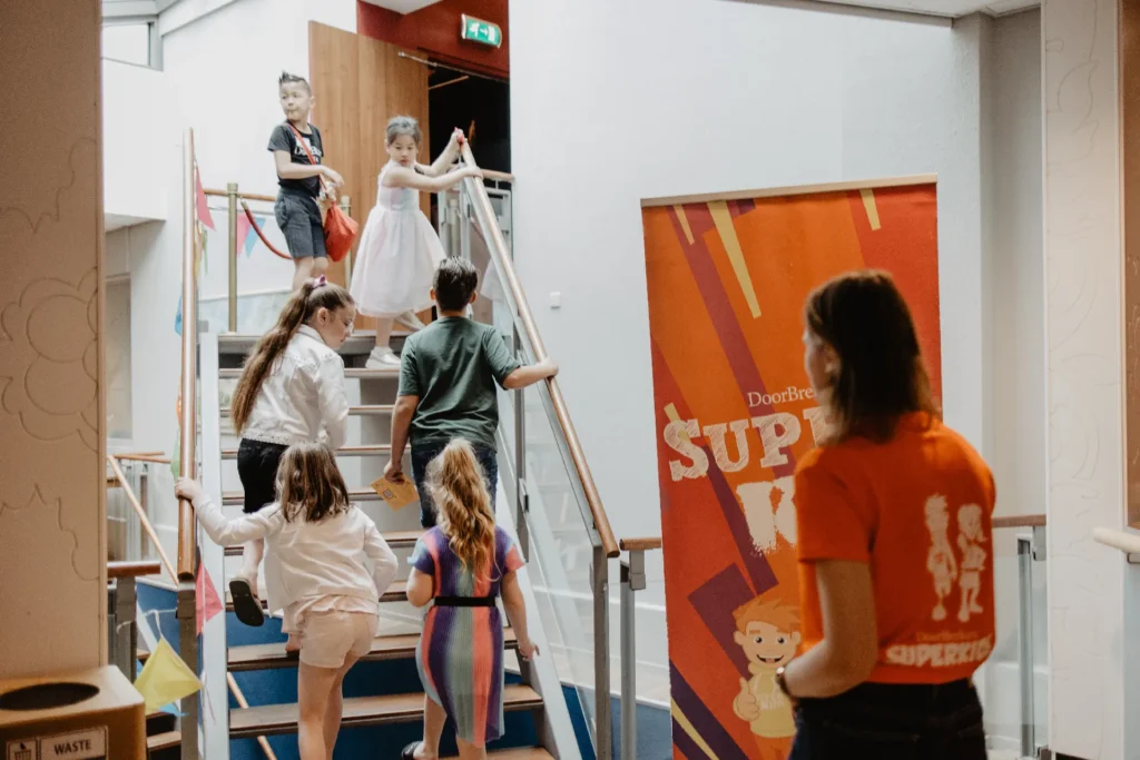 SuperKids begeleider en kinderen lopen naar hun eigen zaal